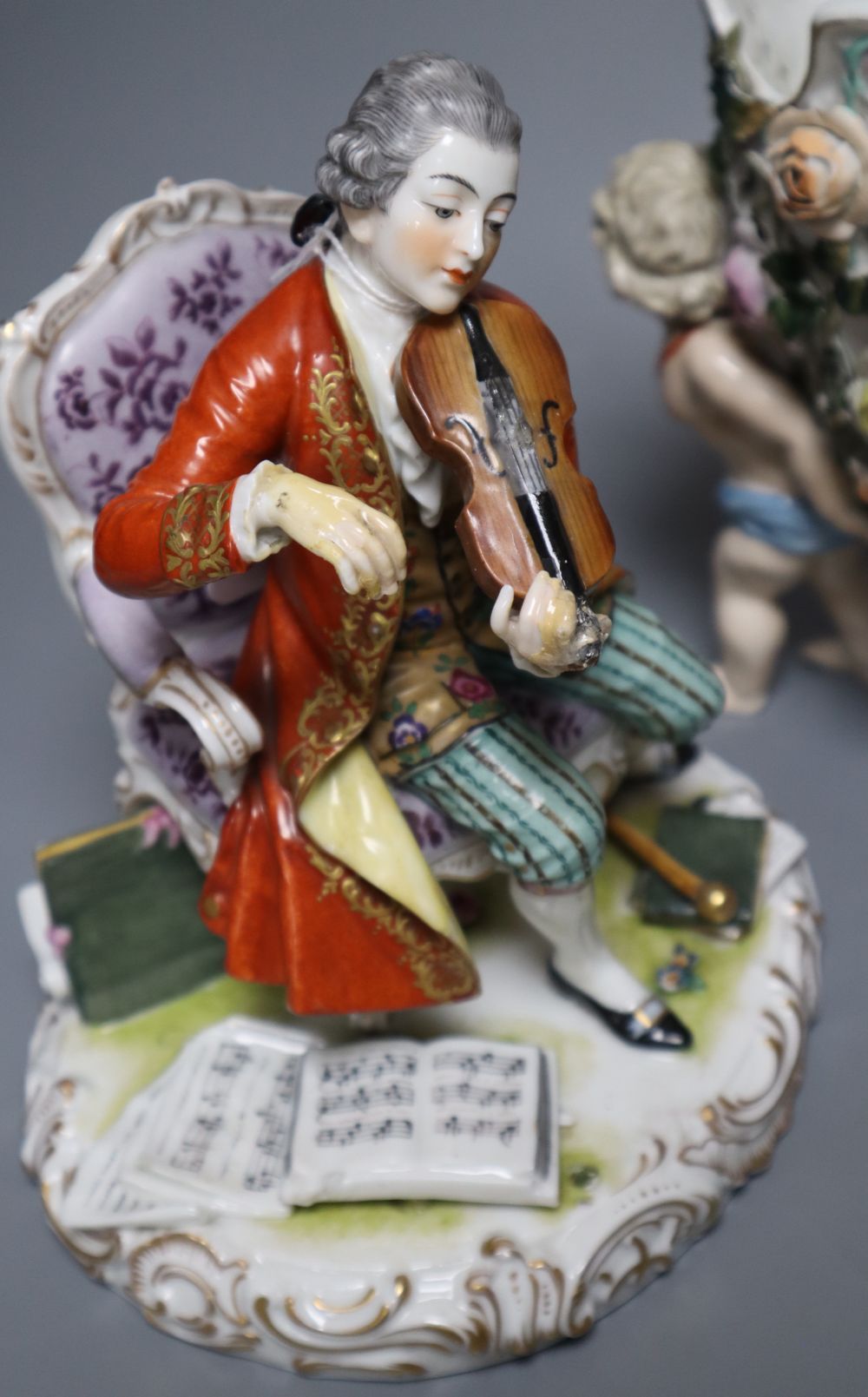 A Meissen style flower-encrusted reticulated oval porcelain jardiniere with cherub supports and three other items,